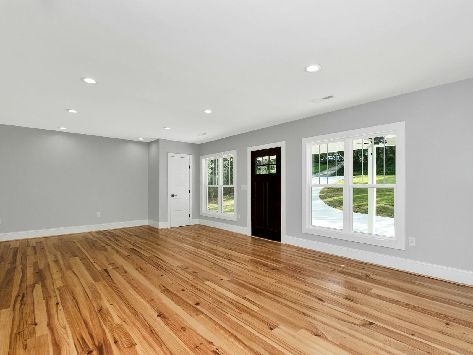 Séjour au parquet satiné où se reflètent les fenêtres