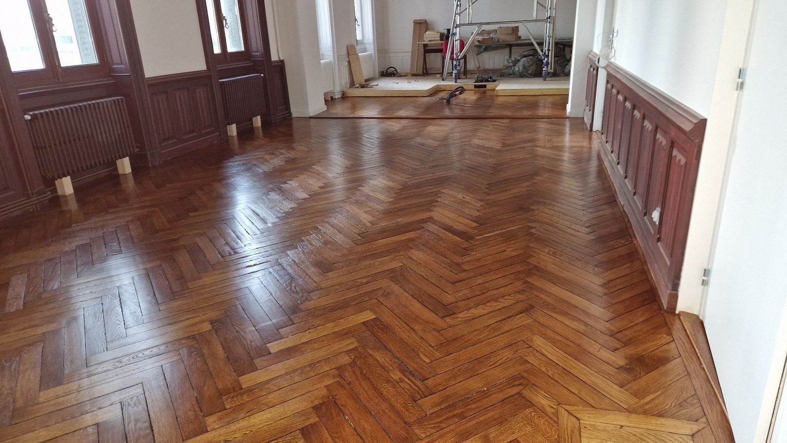 Grand salon au parquet ancien en bâton rompu, brillant après ponçage et vitrification