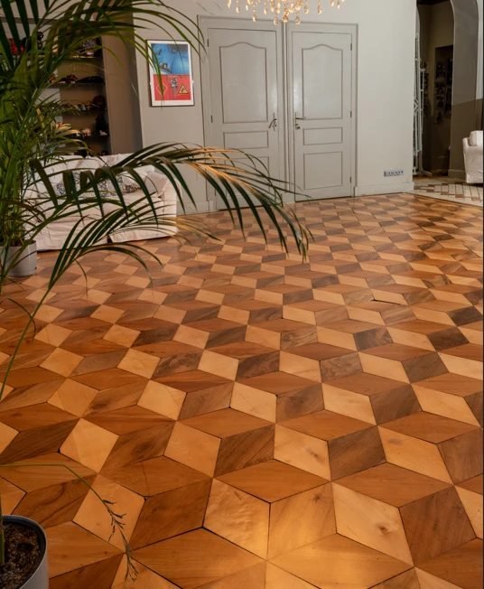 Parquet en losanges clairs, moyens et foncés dans une pièce de réception